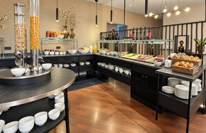 A buffet setup with various food items and beverages. - Leonardo Hotel Magdeburg City Center (Magdeburg)