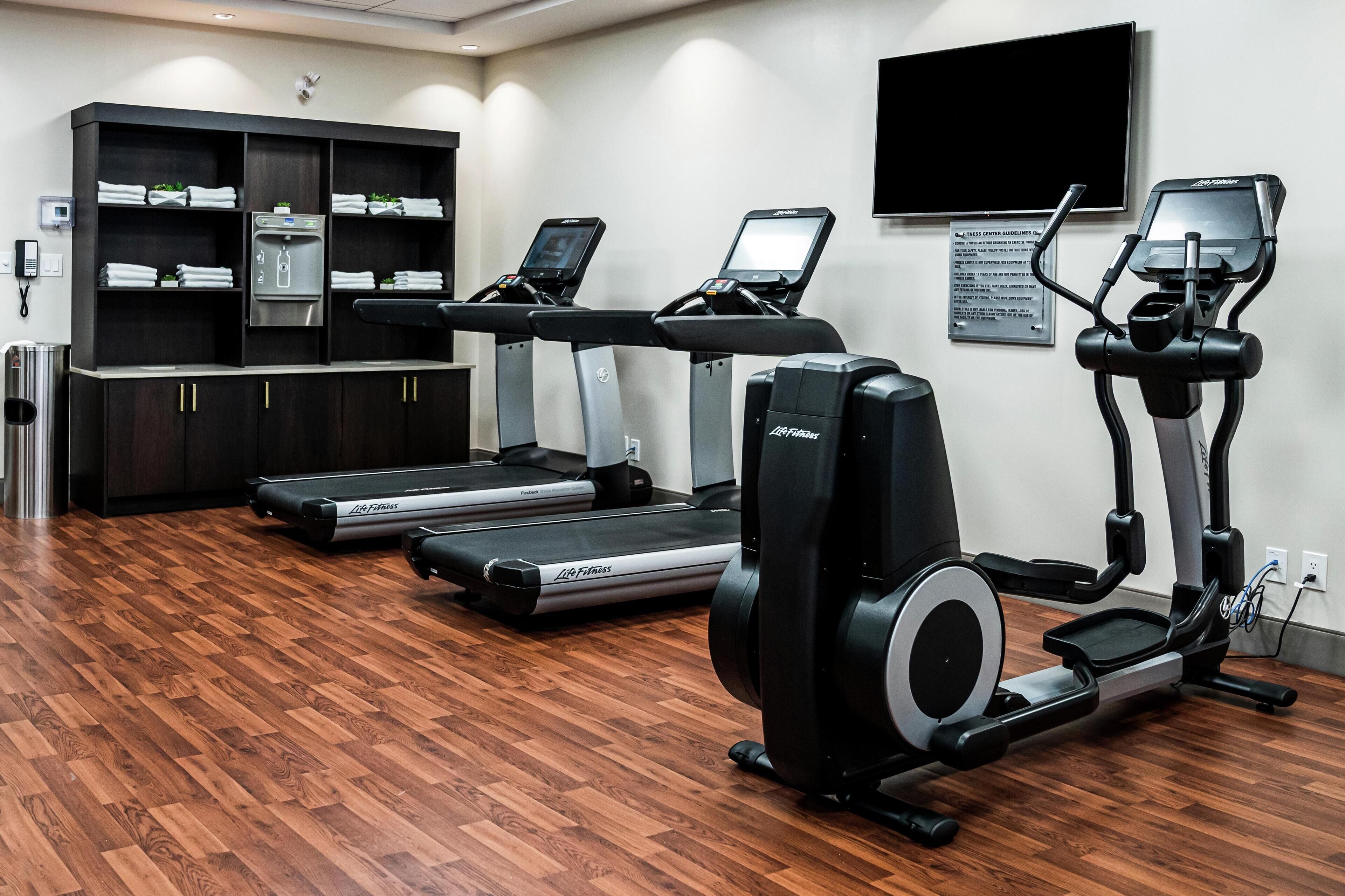 A gym with treadmills, a stationary bike, and a water dispenser.
