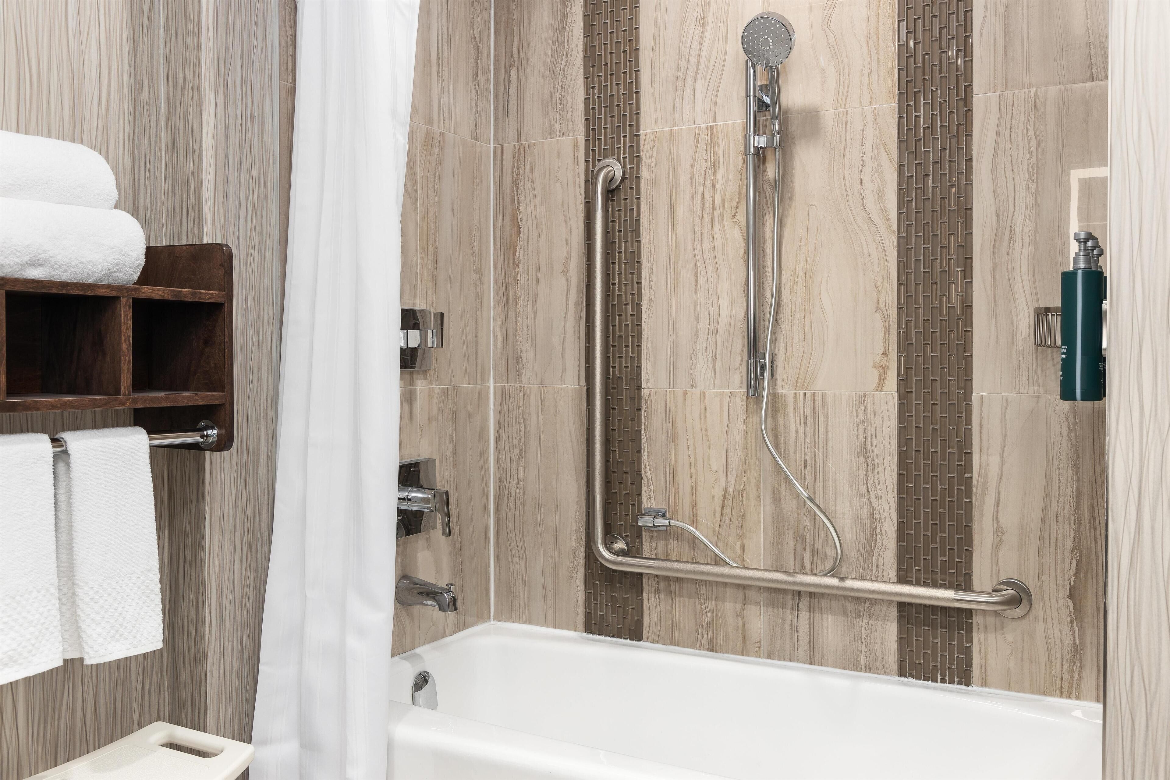 Une salle de bain équipée d’une douche, d’une baignoire et d’un porte-serviettes avec des serviettes.