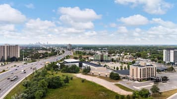A cityscape with a highway, buildings, and greenery.