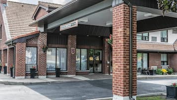 A hotel with a brick facade, large windows, and a covered entrance.