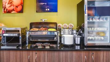 A breakfast bar with a toaster, a grill, and a refrigerator with yogurt containers.