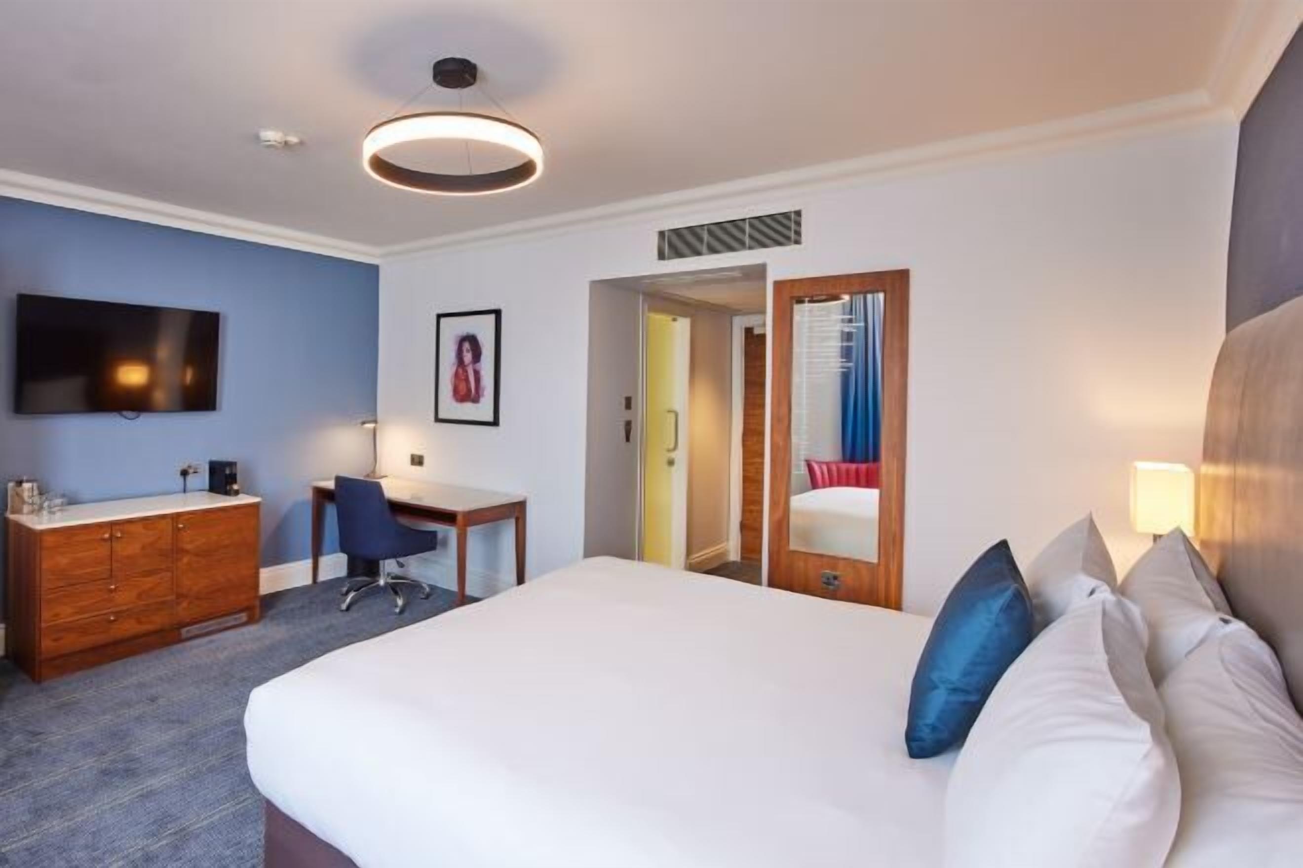 أغطية فراش متميزة وخزنة داخل الغرفة ومكتب ومساحة عمل للكمبيوتر المحمول