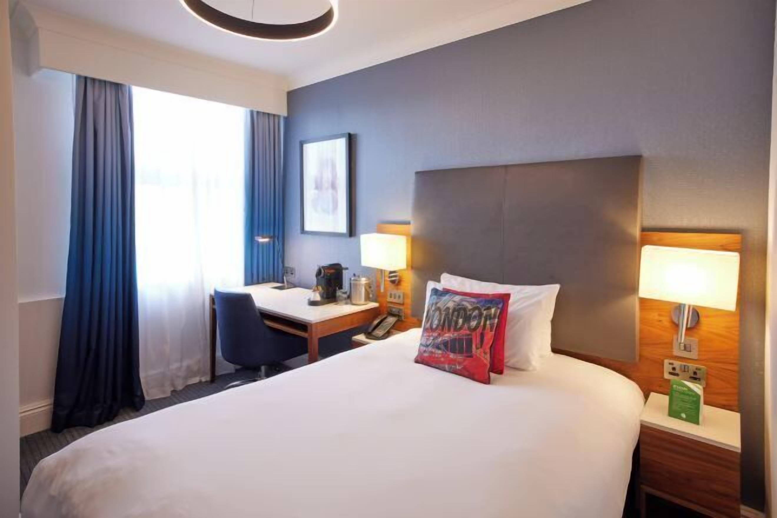 أغطية فراش متميزة وخزنة داخل الغرفة ومكتب ومساحة عمل للكمبيوتر المحمول