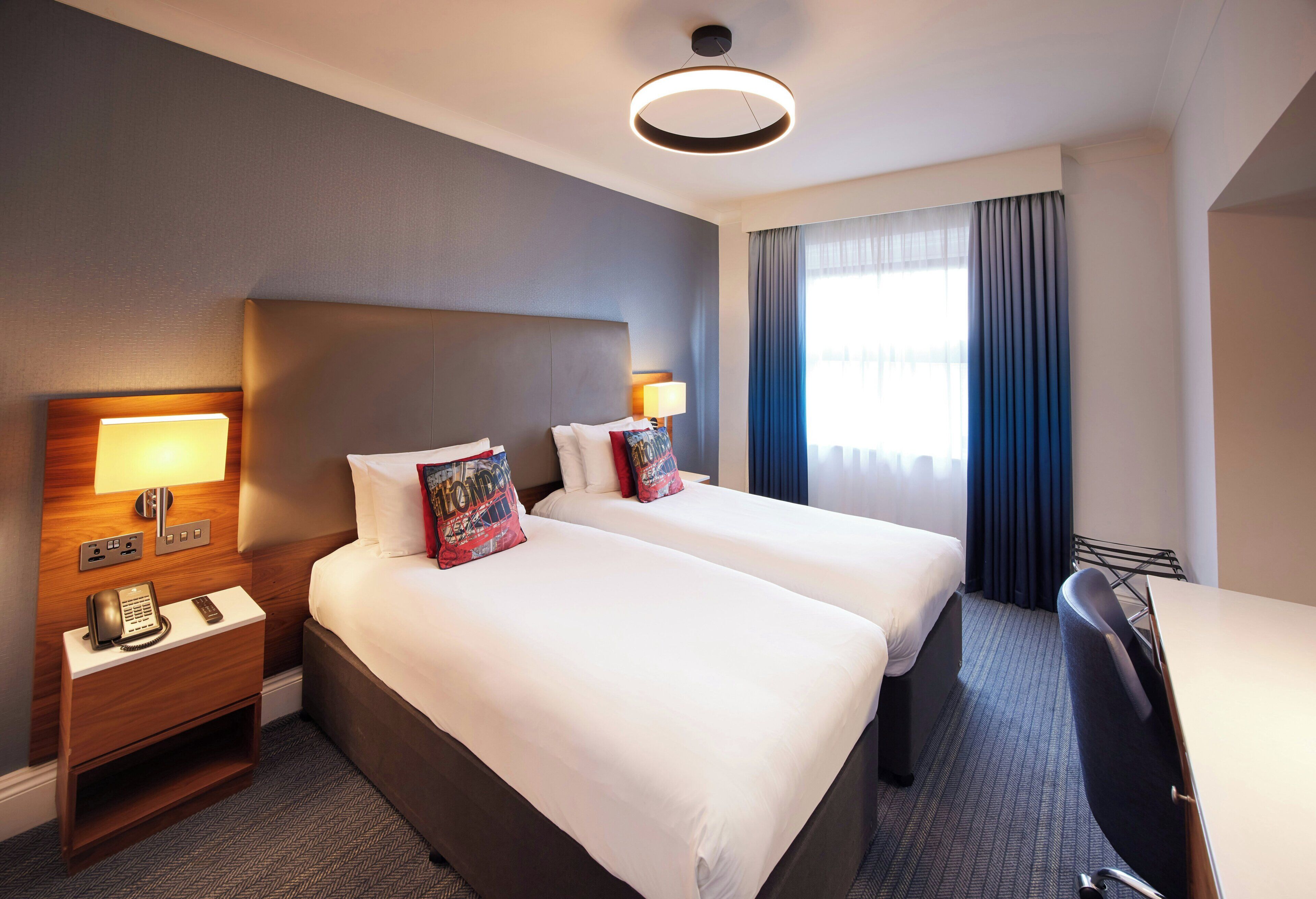 أغطية فراش متميزة وخزنة داخل الغرفة ومكتب ومساحة عمل للكمبيوتر المحمول