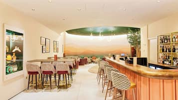 A bar area with a curved counter, multiple bar stools, and a wall-mounted wine rack.