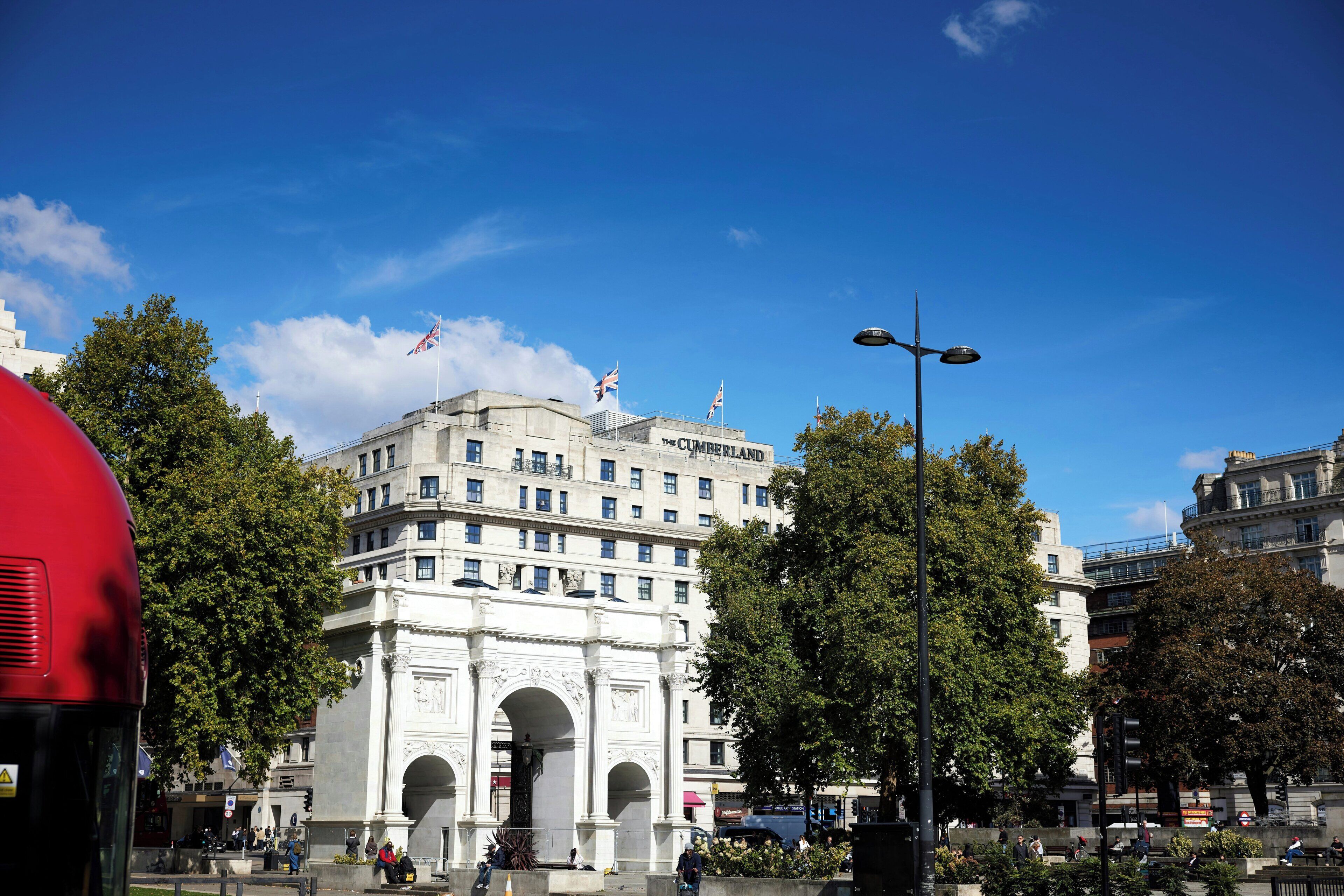 A historic building with a prominent archway, multiple windows, and flags.