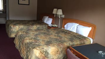 Habitación de hotel con dos camas, un escritorio y una silla.