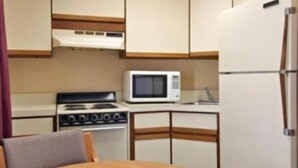 Una cocina compacta con estufa, microondas y refrigerador.