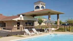 Una piscina con sillas de descanso y una zona cubierta.