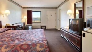 Una habitación de hotel con una cama grande, televisor, escritorio y una silla.