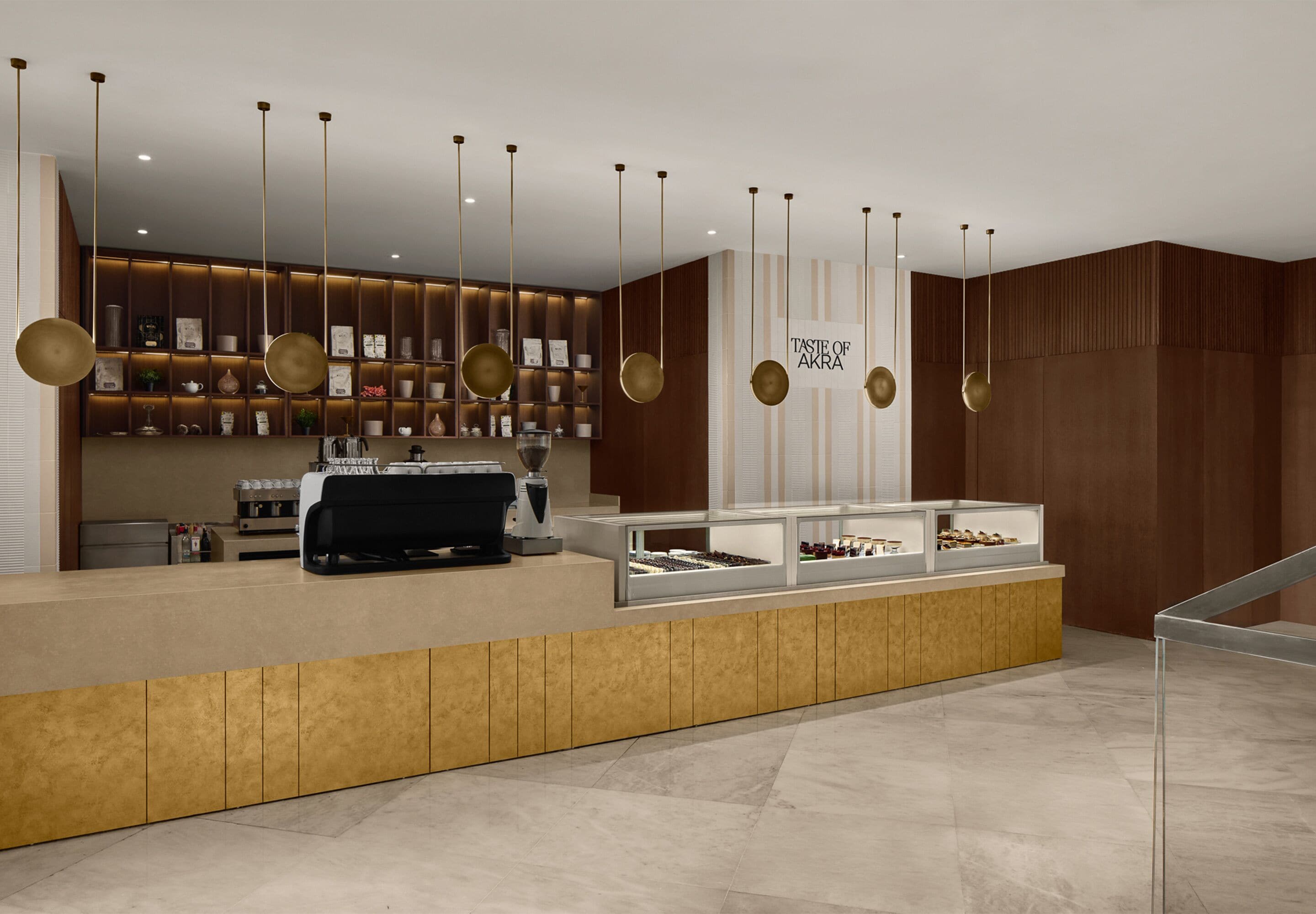 Un área de recepción moderna con mostrador, vitrinas y una pared con estanterías.