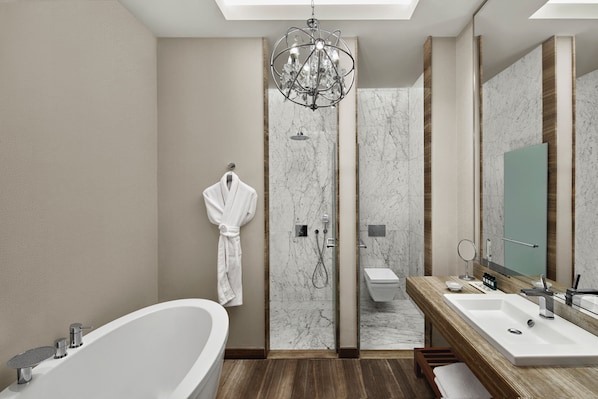 A modern bathroom with a freestanding bathtub, a walk-in shower, and a vanity with a large mirror. - Akra Antalya (Antalya)