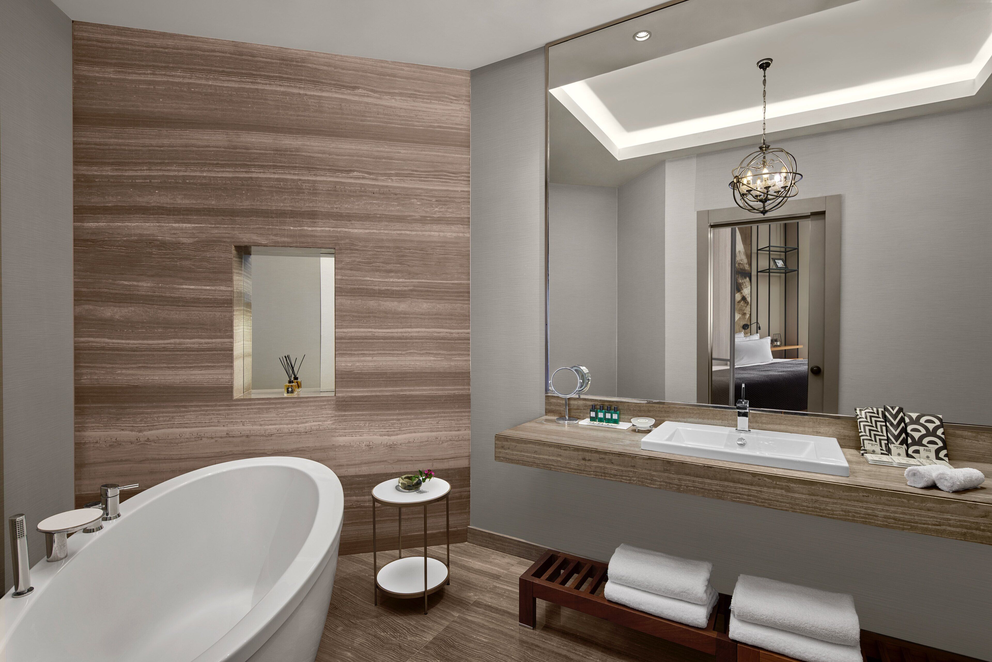 Un baño moderno con una bañera independiente, un tocador con espejo y un aplique de techo.