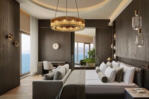 A modern bedroom with a large bed, a desk, and a view of the sea. - Akra Antalya (Antalya)