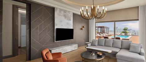 A modern living room with a large flat-screen TV, a grey sectional sofa, and orange armchairs.