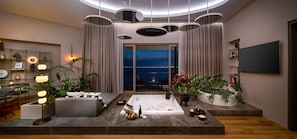 A modern living room with a large window, a sofa, a coffee table, and a TV. - Akra Antalya (Antalya)