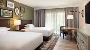 Een hotelkamer met twee bedden, een bureau, een stoel, een televisie en een raam met gordijnen.