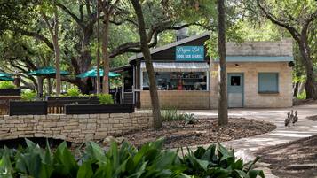 A small building labeled 'Papa Ed's Pool Bar & Grill' with outdoor seating and a stone wall.