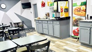 A restaurant with tables and chairs, a clock on the wall, and a menu board. - Quality Inn Raynham - Taunton (Raynham)