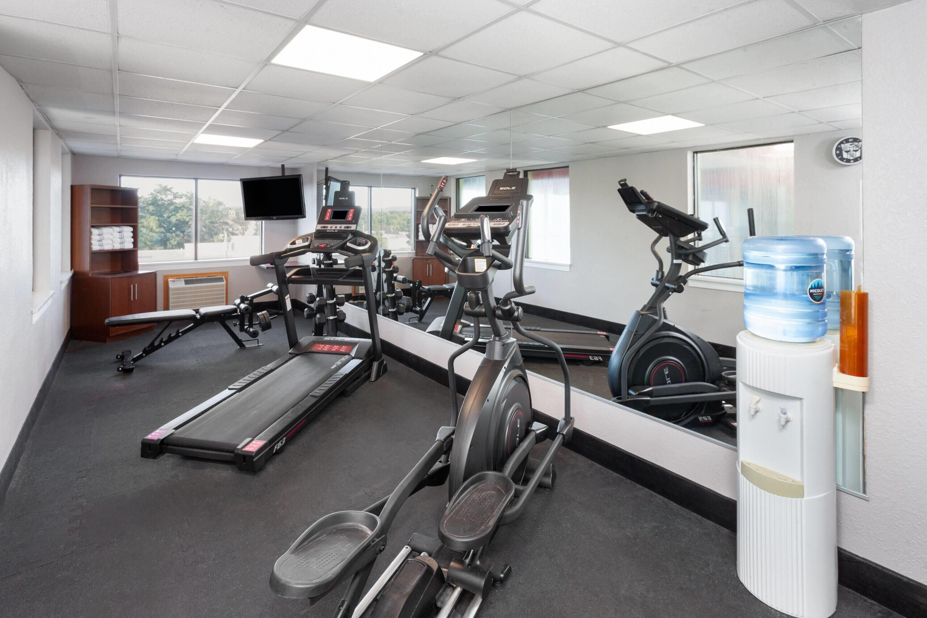 A gym with treadmills, elliptical machines, and weight equipment.
