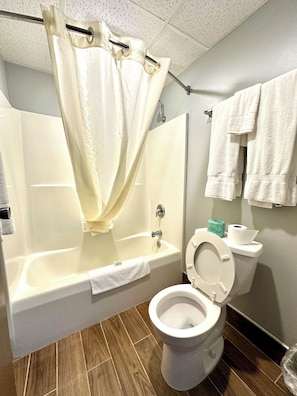 Bathroom features a bathtub, toilet, and tiled floor.