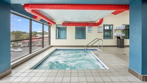 Une piscine donnant sur l’extérieur, un plafond rouge et un panneau indiquant l’emplacement du sauna.