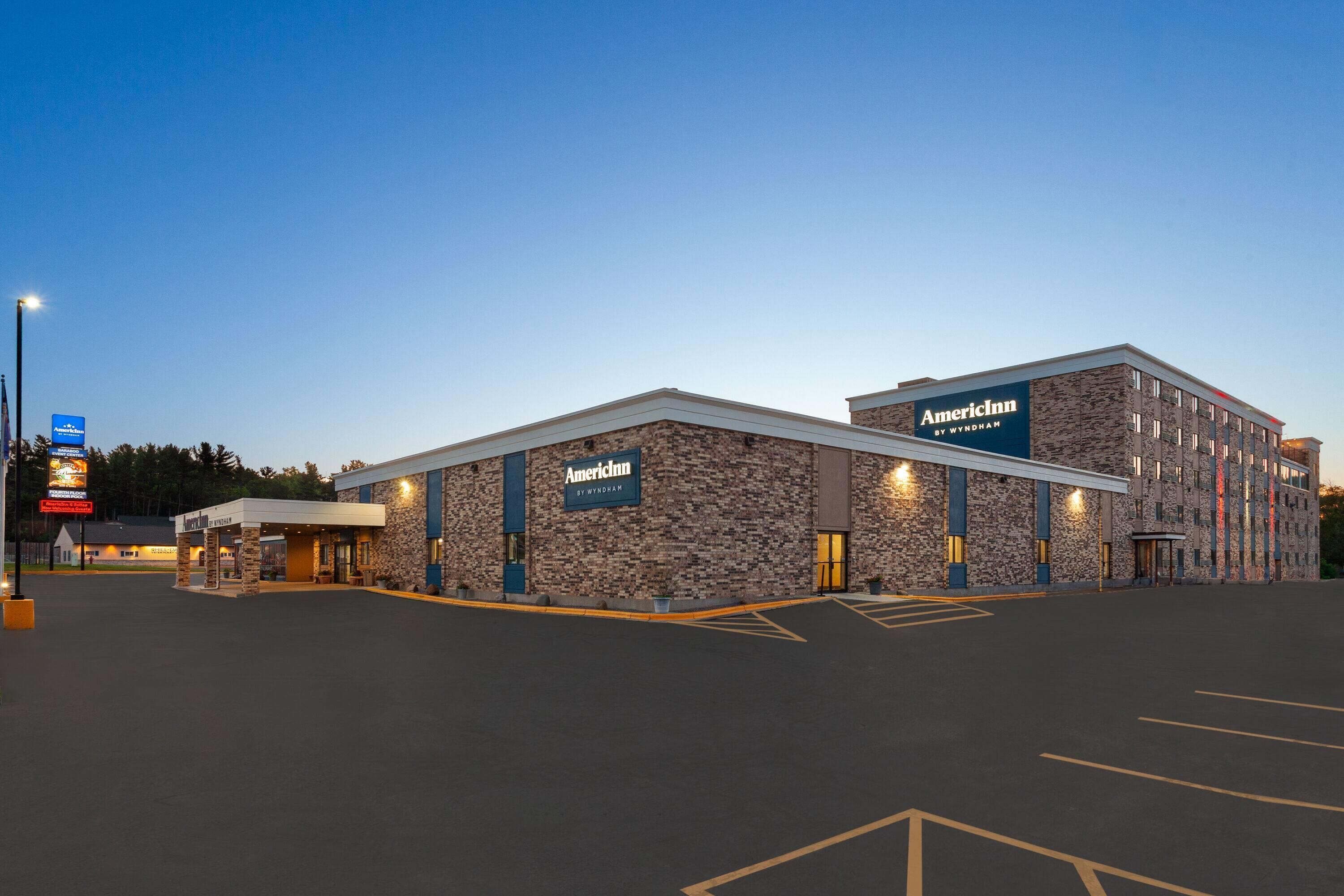 A hotel with a stone facade, multiple entry points, and a parking lot.