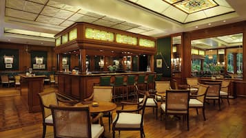 A bar area with wooden furniture and a green wall.
