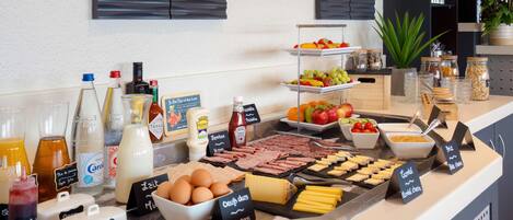 Un bufé de desayuno con diversas opciones de comida y acompañamientos.