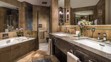 A modern bathroom with two sinks, a glass shower enclosure, and a large mirror.