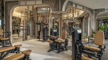 A modern gym with various exercise equipment, including weight machines and benches.