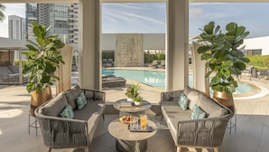 A rooftop lounge with a pool, outdoor seating, and large potted plants. - Four Seasons Hotel Singapore (Singapore)