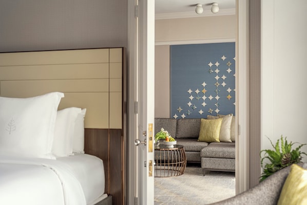 A hotel room with a bed, a sofa, and a decorative wall.