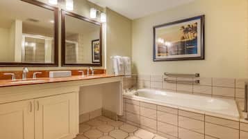 Un baño con un espejo grande, una bañera y un tocador con lavabo.