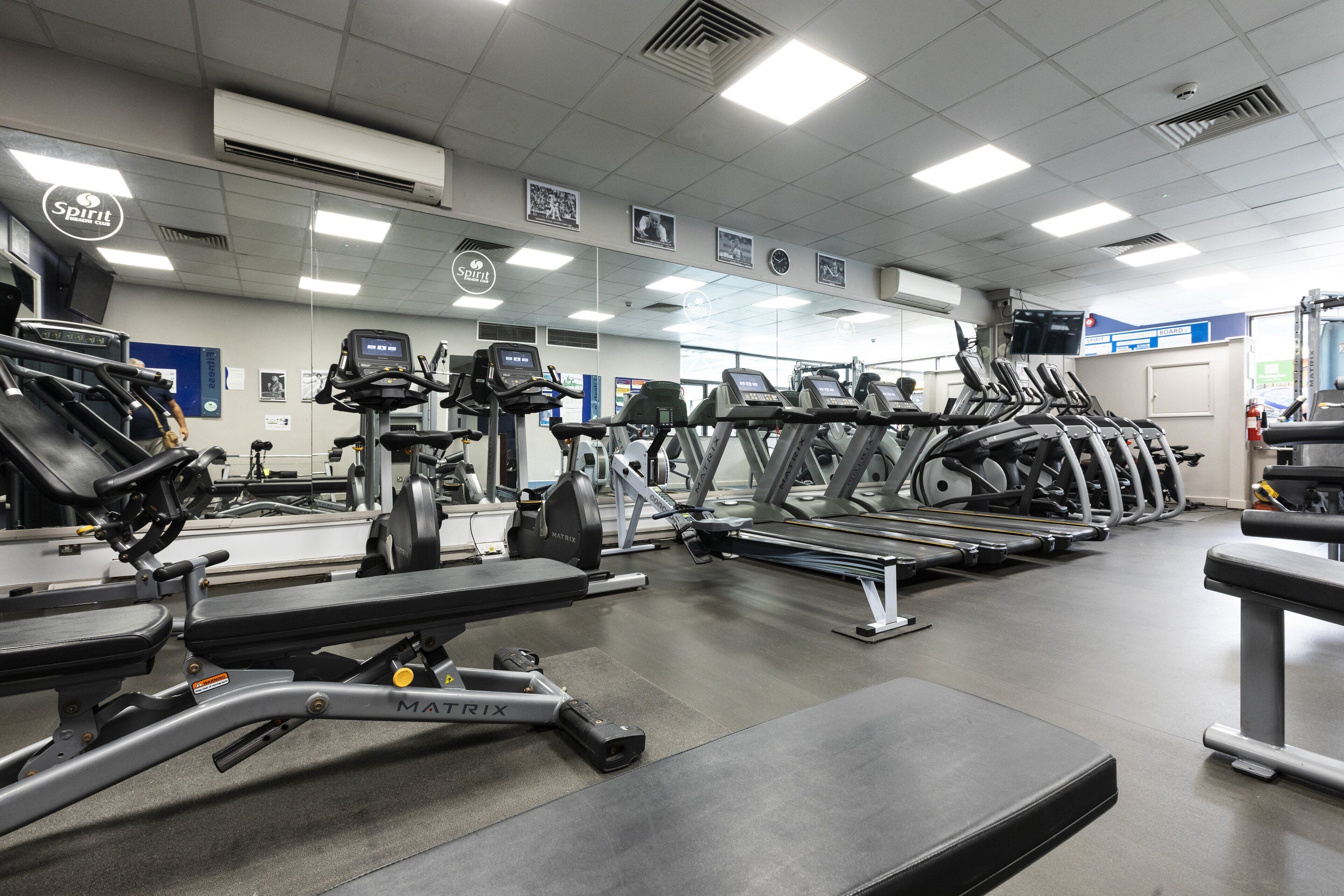A gym with treadmills, elliptical machines, and weight benches.