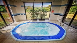 Un bain à remous avec vue sur les arbres et un panneau indiquant « Il est interdit de plonger ».