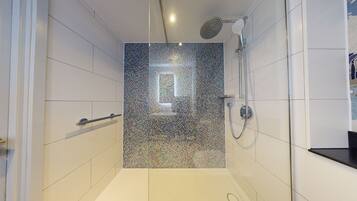 A modern bathroom with a shower, tiled walls, and a visible window.