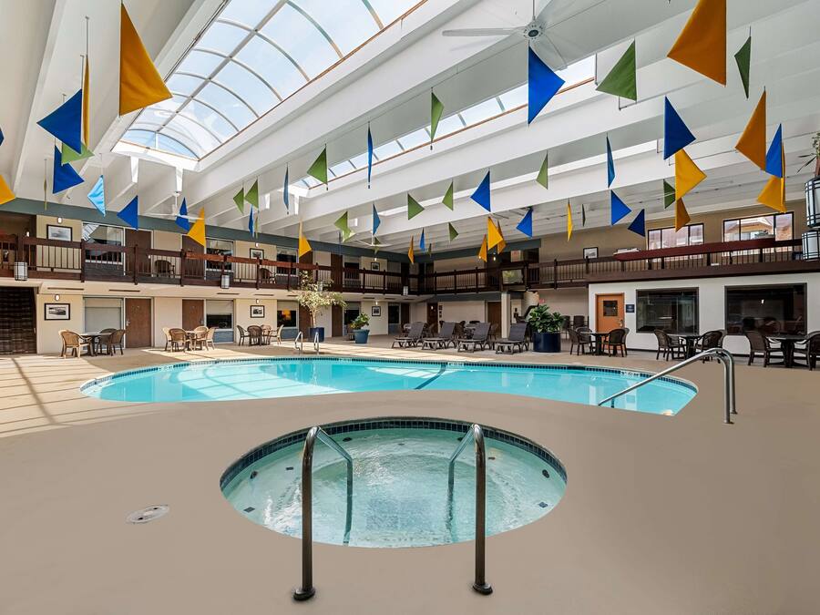 Een binnenzwembad, ligstoelen bij het zwembad