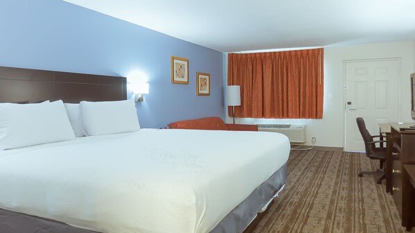 Relax in this inviting space with a large bed, desk, and comfortable chair.