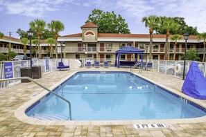 Una piscina al aire libre, camas de piscina gratis, sombrillas