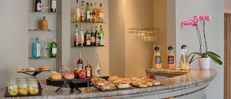 A bar area with various bottles, glasses, and food items.