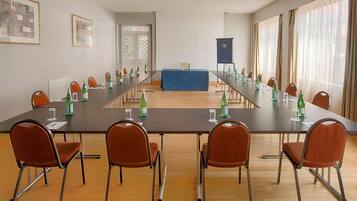 A conference room with a long table, chairs, and a podium.