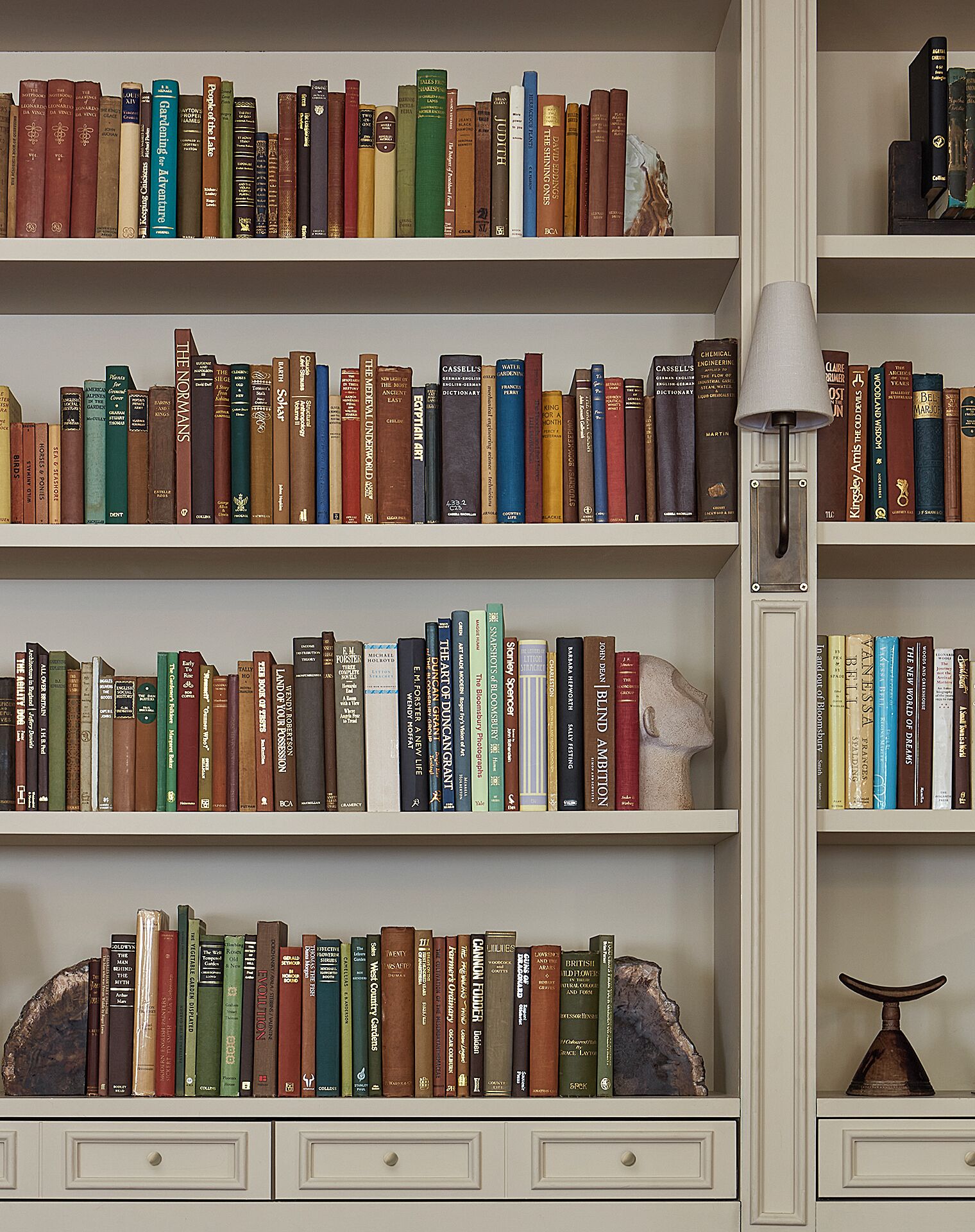 Ein Bücherregal mit verschiedenen Büchern, einer Lampe und Dekorationselementen.
