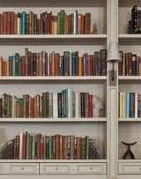 A bookshelf filled with various books, a lamp, and decorative items.