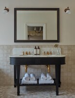 A bathroom with a dark wooden vanity, two sinks, and a large mirror above.