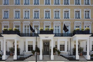 Un edificio de varios pisos con una fachada simétrica, que presenta una entrada central con escalones, columnas y un letrero que dice "Templeton Garden".