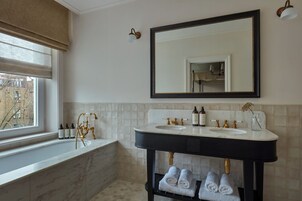 Ein Badezimmer mit zwei Waschbecken, einem großen Spiegel und einer Badewanne.