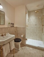 A bathroom with a sink, toilet, and glass-enclosed shower.