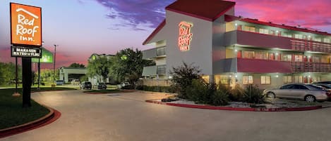 A Red Roof Inn with a parking lot and a building with multiple floors.